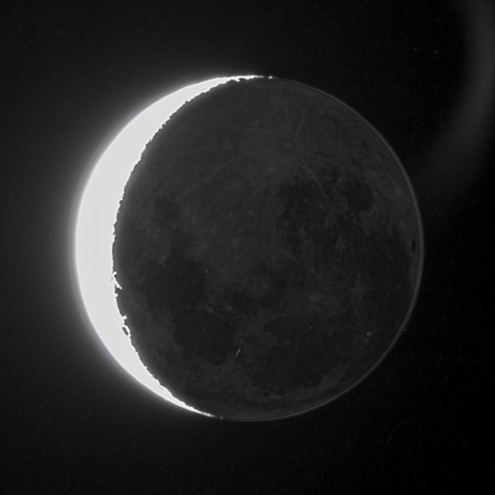 A crescent Moon burnt to pure white, with the dark side softly visible